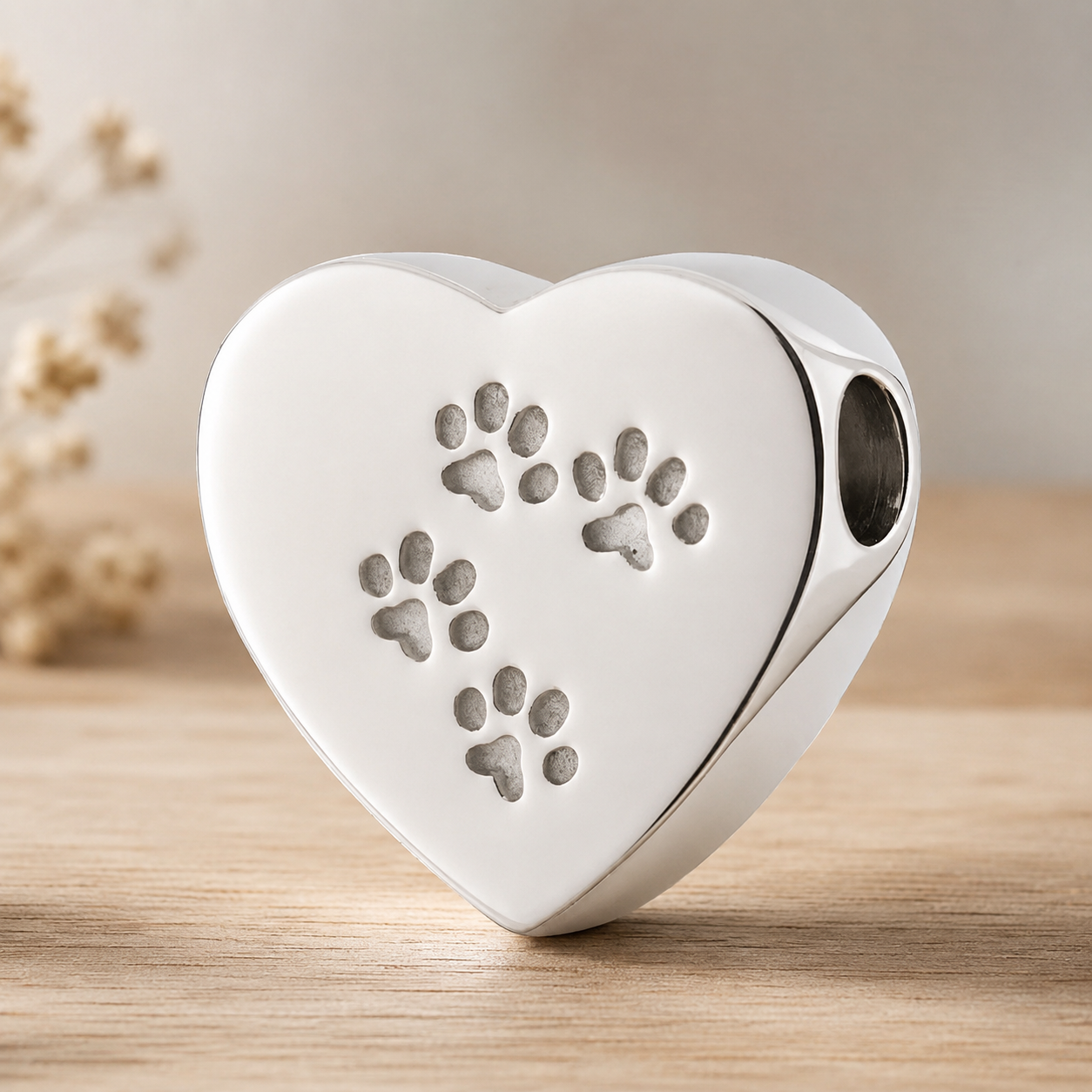 Hartvormige ashanger met pootafdrukken van RVS. Herinneringssieraad voor hond of kat, geschikt voor het bewaren van een symbolische hoeveelheid as van een geliefd huisdier.