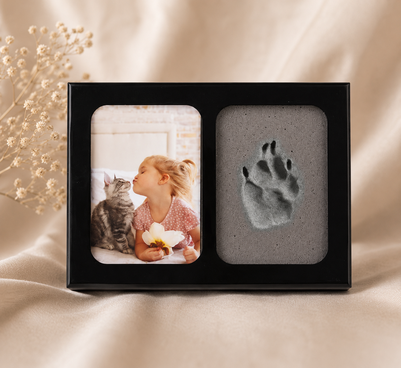Herinneringsfotolijst met pootafdruk van huisdier en foto van kind met kat – stijlvolle zwarte lijst op zachte beige achtergrond, liefdevolle herinnering aan een geliefd huisdier.